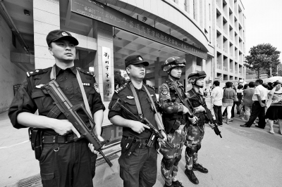 高考首日大学生为考生送西瓜特警持枪“保驾”