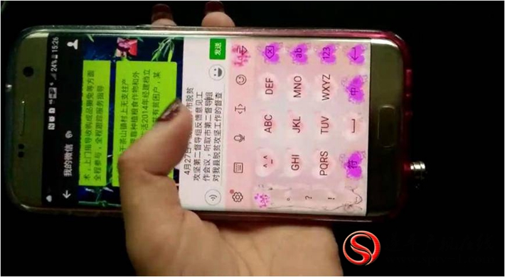 图为:5月19日,因暴雨停电县扶贫办工作人员用手机写材料。