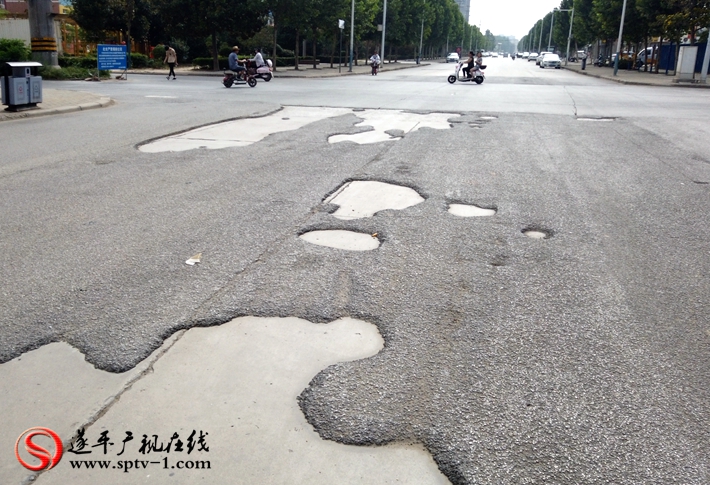 上图:遂周路与金山路交叉口柏油路面破损严重,坑洼不平。